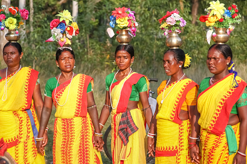 West Bengal, India, November 2,2019: Tribal women in traditional costumes perform folk dance in a forested area at Bolpur Shantiniketan, West Bengal